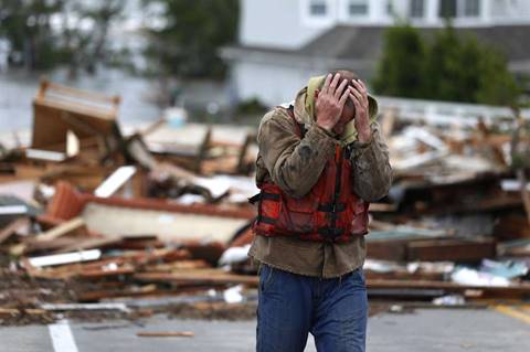 Brian Hajeski, 41, of Brick, N.J., reacts after looking at debris of a home that washed up on to the Mantoloking Bridge the morning after superstorm Sandy rolled through in 2012. Photo: Julio Cortez, Associated Press