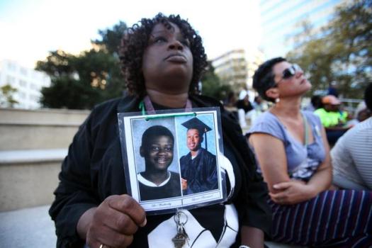 Dinyal New, holds photos of her two sons Lee Weathersby III, 13, and Lamar Broussard, 19, during a vigil for homicide victims of last year and this year at Frank Ogawa Plaza in Oakland, Calif., on Thursday, Sept. 25, 2014. Broussard was killed three weeks after his younger brother Weathersby was gunned down on New Year's eve of 2014. The vigil was organized by Khadafy Foundation for Non-Violence, a grief support group for parents who have lost a child due to violence. (Ray Chavez/Bay Area News Group)
