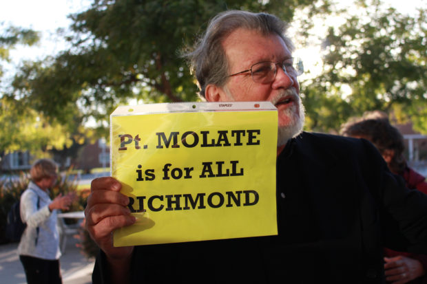 Richmond resident Juan Reardon holds a sign protesting the Point Molate settlement outside City Hall on Tuesday, Sept. 25. Reardon later called the deal between the city and developers a 