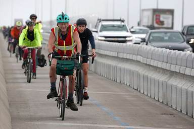 Bicyclists complete their inaugural ride across the Richmond-San Rafael Bridge after the new bike and pedestrian path on the span opened to the public.
