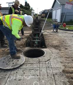Forde connecting new pipe to existing manhole on Florida 2
