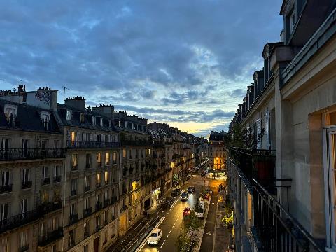 A street with buildings and cars on it    Description automatically generated